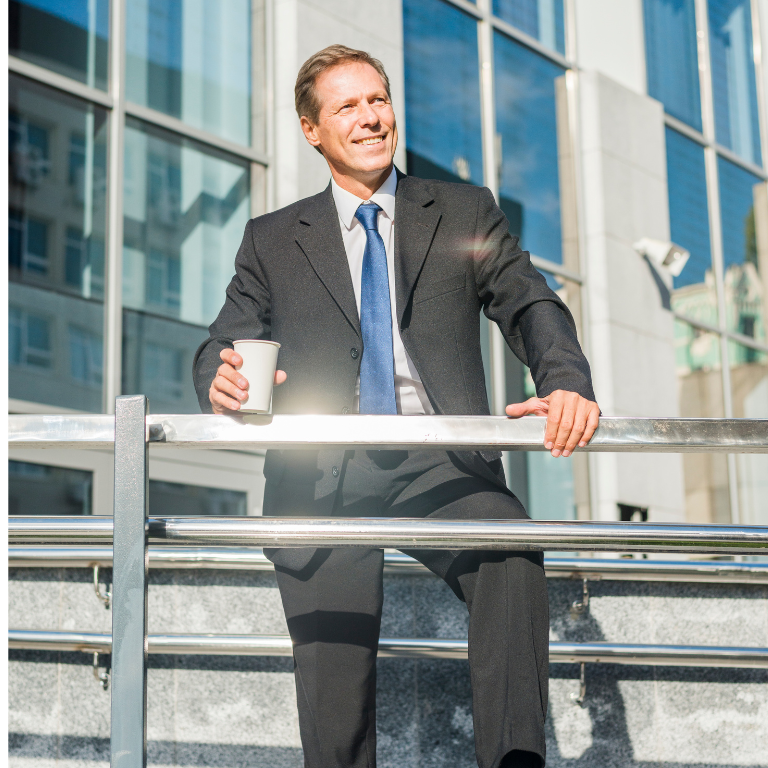 happy-businessman-with-cup-coffee-standing-front-building
